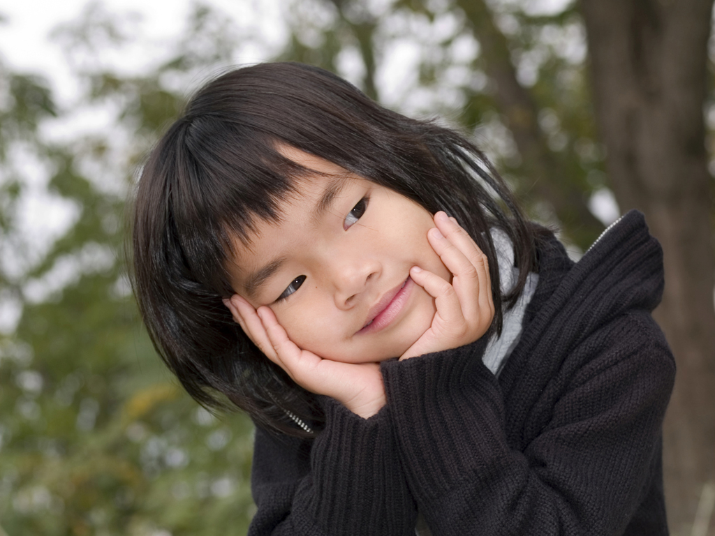 Little girl smiling with her head in her hands Little girl smiling with her head in her hands